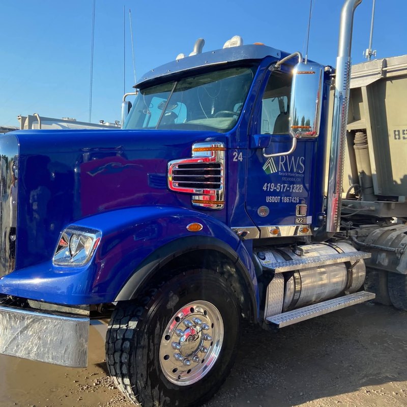 Glossy blue tractor numbered 24 with a company logo on the door and a shining wheel.